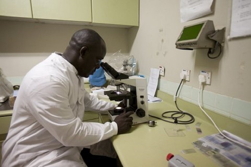 researcher looking through microscope