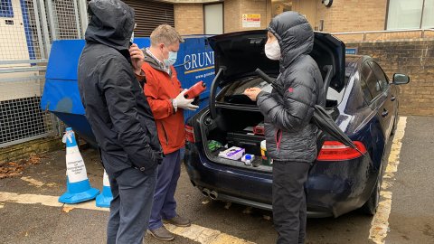 VIE team members looking at items in the boot of a car
